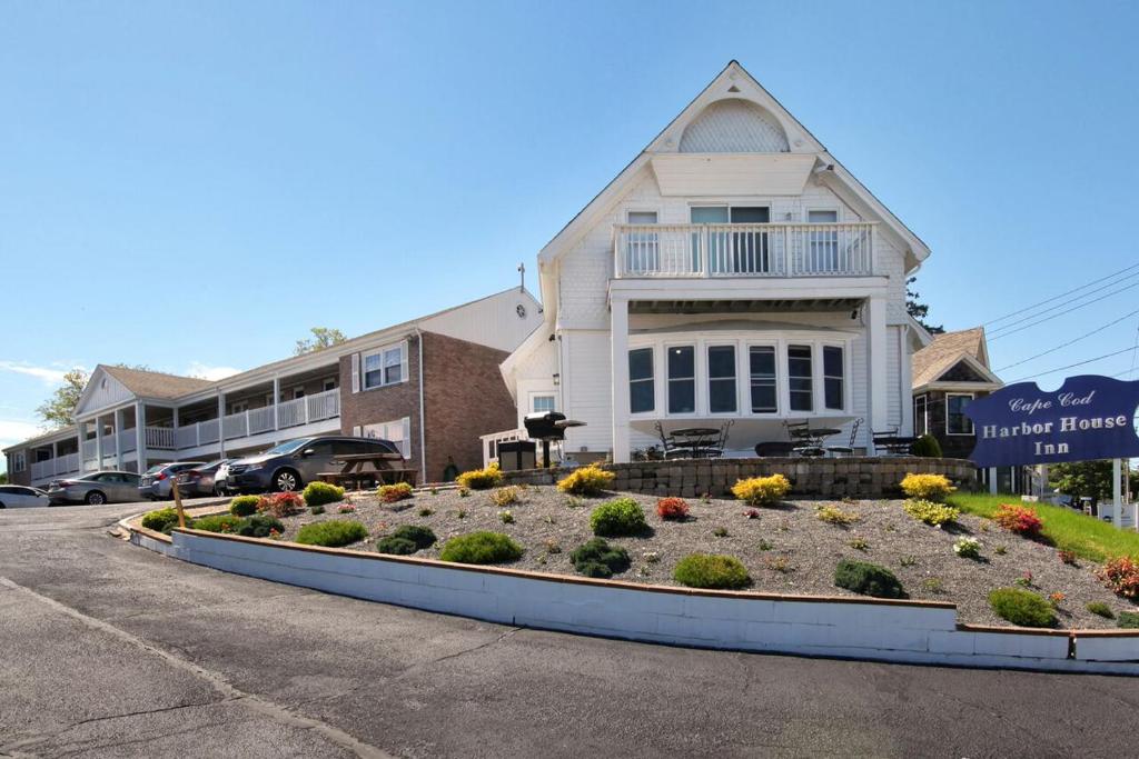 ein Haus mit einem Blumenbett davor in der Unterkunft Cape Cod Harbor House Inn in Hyannis