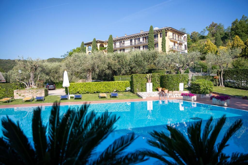 a large swimming pool in front of a building at Residence San Michele in Costermano