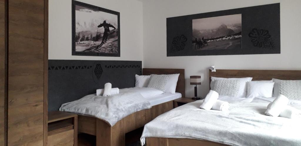 1 Schlafzimmer mit 2 Betten und weißer Bettwäsche in der Unterkunft Pokoje Gościnne KAMI in Zakopane