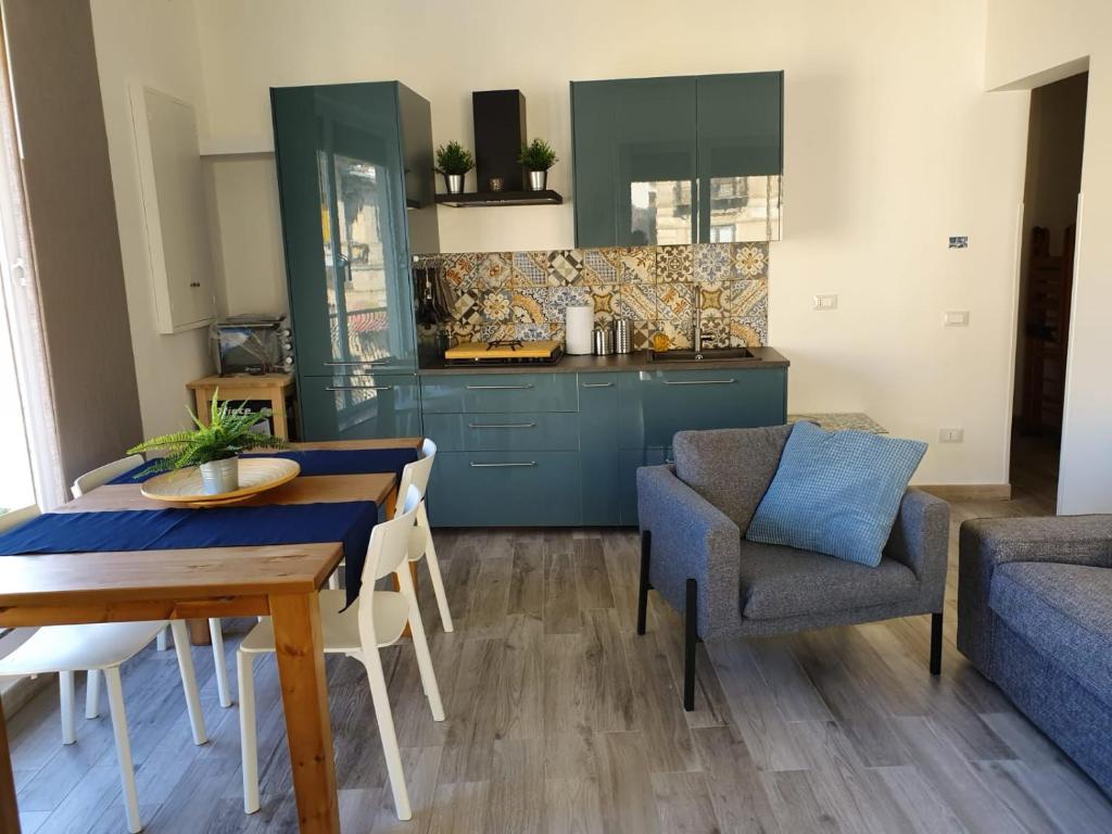 a living room with a table and chairs and a kitchen at Casa del Moro in Cefalù