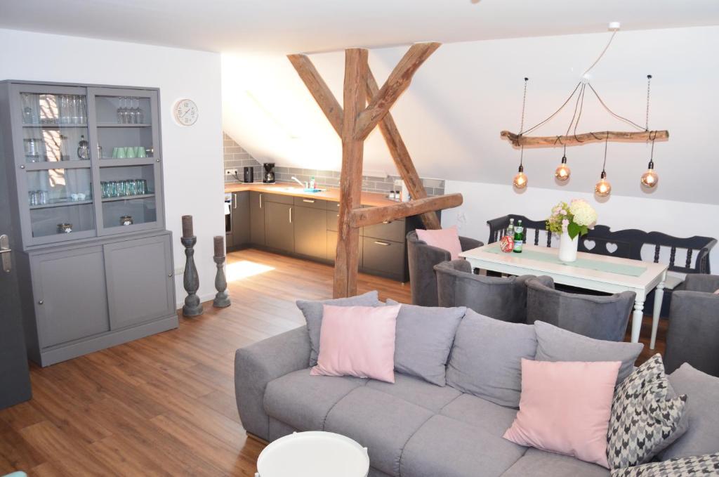 a living room with a gray couch and a kitchen at Hygge in Clenze