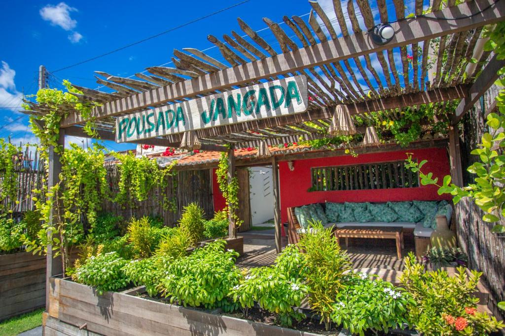 una pérgola con un banco en un jardín en Pousada Jangada Prea, en Prea