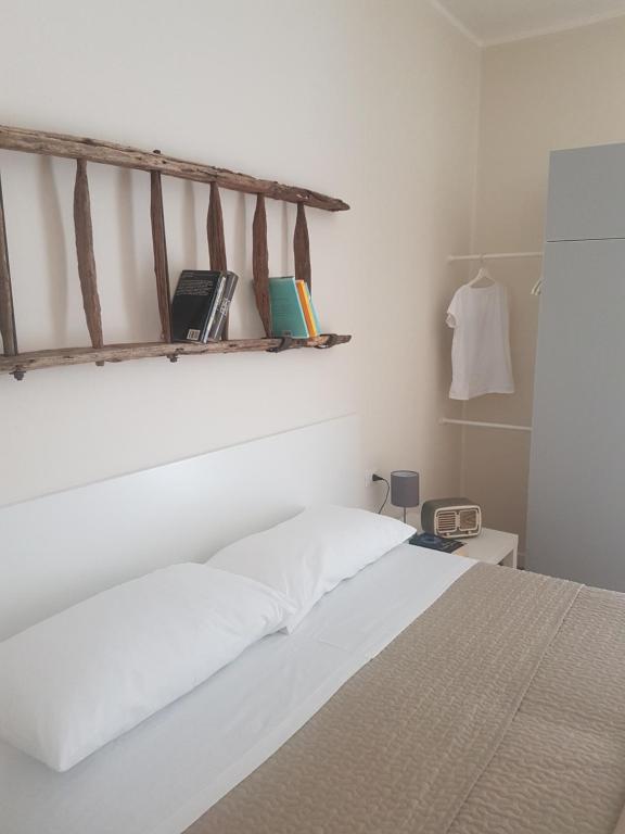 sypialnia z białym łóżkiem i półką z książkami w obiekcie Affittacamere La Scala w mieście Lecco