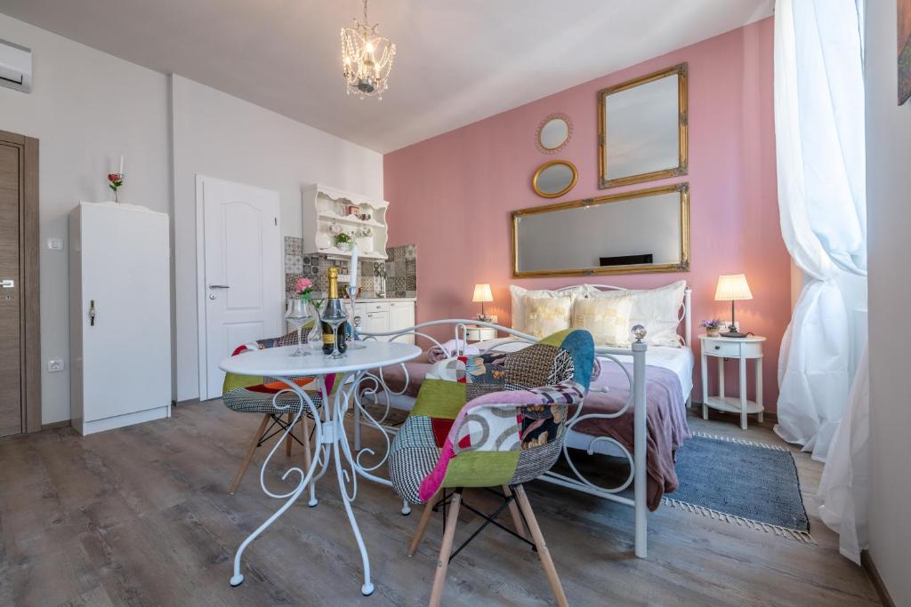 sypialnia z łóżkiem, stołem i krzesłami w obiekcie Old City Romantic Studios 3 w Puli