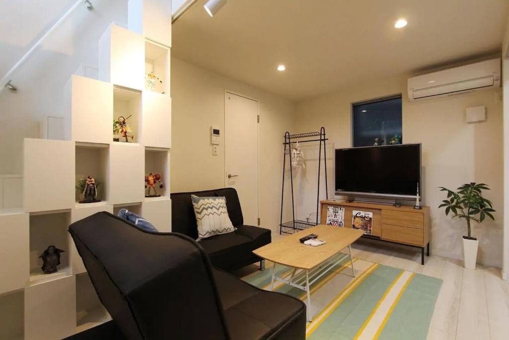 a living room with a couch and a tv and a table at Building A101 / Vacation STAY 1275 in Tokyo