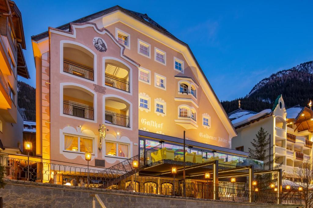 a large yellow building with a clock on it at Hotel Goldener Adler in Ischgl