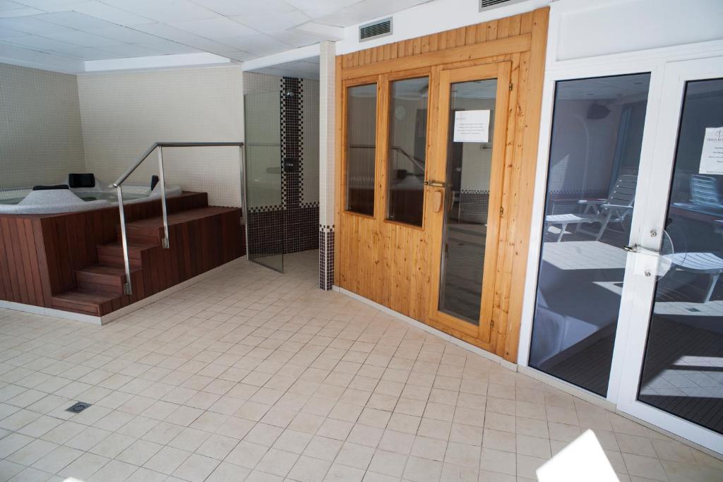 Habitación con puerta de madera y suelo de baldosa. en Obaga Blanca & Spa, en Canillo
