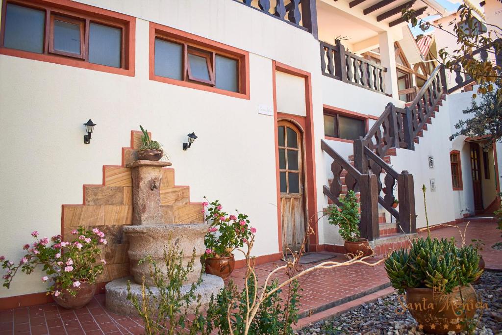 a house with stairs and potted plants in front of it at Hotel Santa Mónica in Potosí