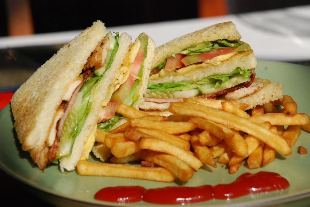 a sandwich and french fries on a plate with ketchup at Royal Crown Hotel & Spa in Siem Reap