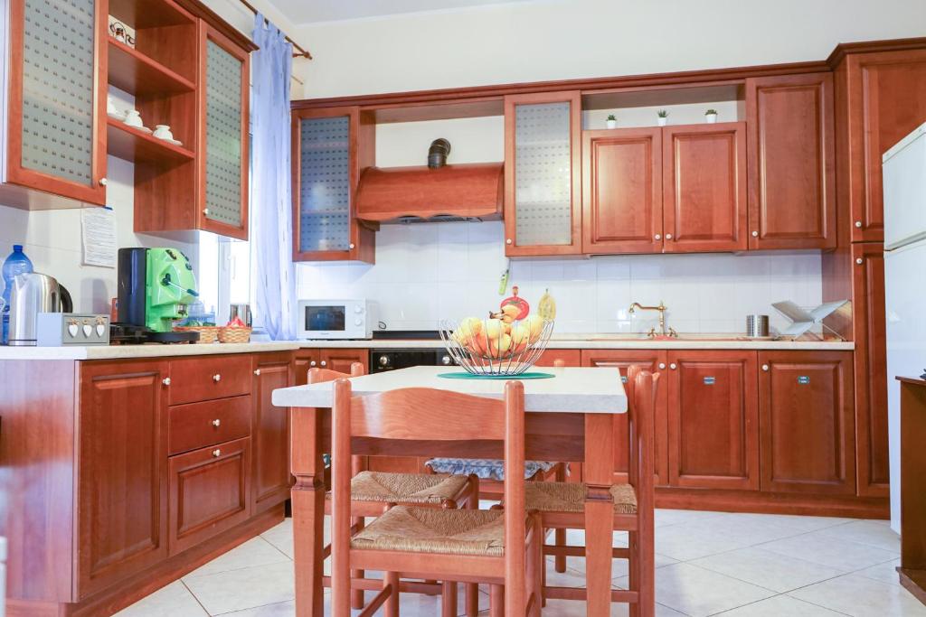 uma cozinha com armários de madeira e uma mesa com frutas em B&B San Francesco em Nicosia