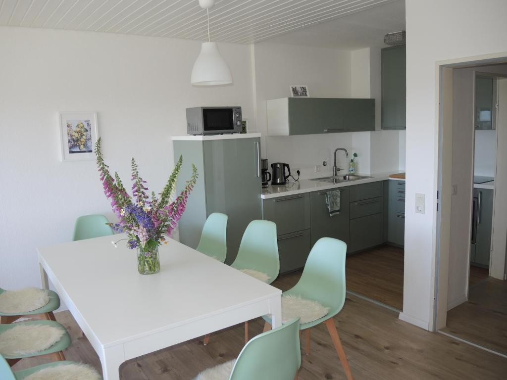 a kitchen and dining room with a white table and chairs at Ferienwohnung Saig in Lenzkirch