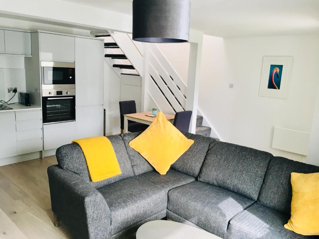 a living room with a couch and a staircase at 1 Shiphouse Apartment in Lamlash