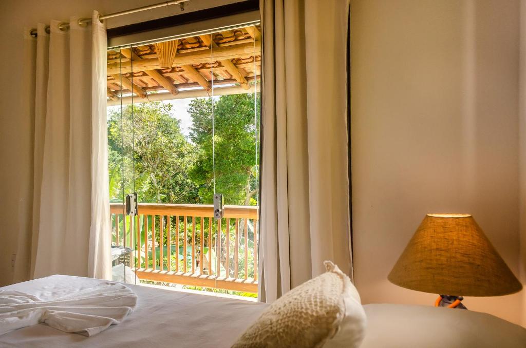 ein Schlafzimmer mit einem Bett und einem großen Fenster in der Unterkunft Residencial Solares in Trancoso