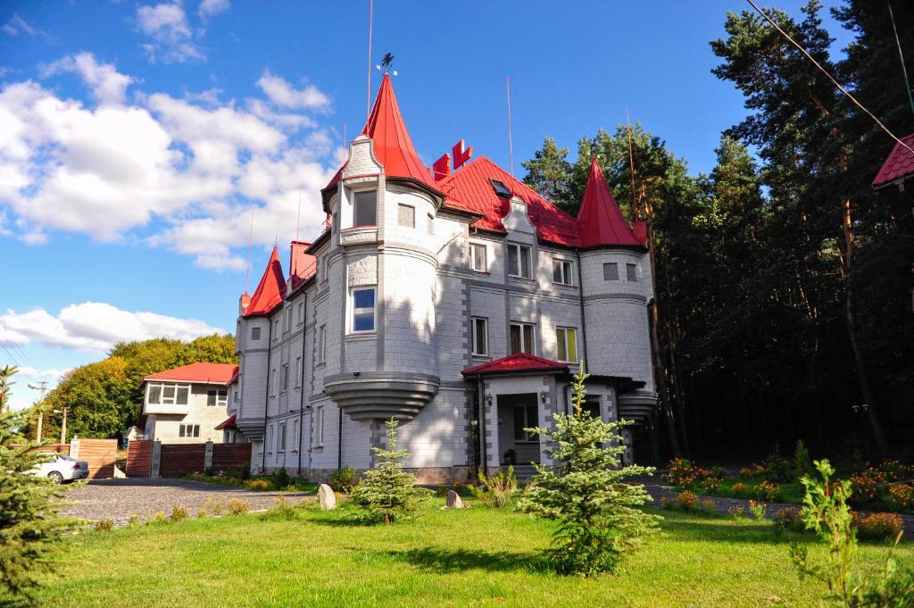 a castle with a red roof on top of a yard at Oazis-M in Babin
