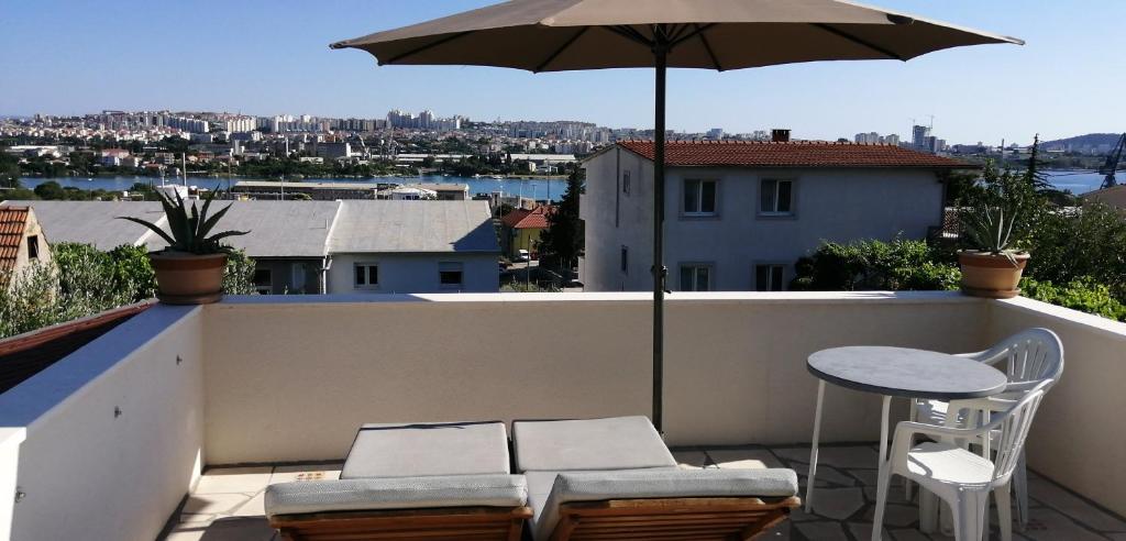 a balcony with an umbrella and a table and chairs at Stone Guest House in Split