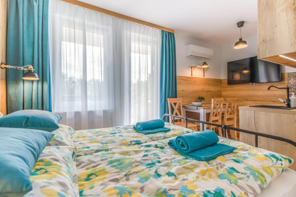 a bedroom with a bed with blue pillows on it at APARTAMENT MEWA in Sztutowo