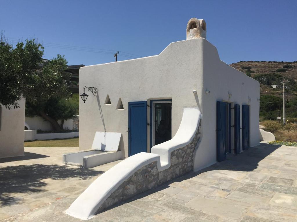um pequeno edifício branco com escadas em frente em Seafront Villa Polyxene em Keratea