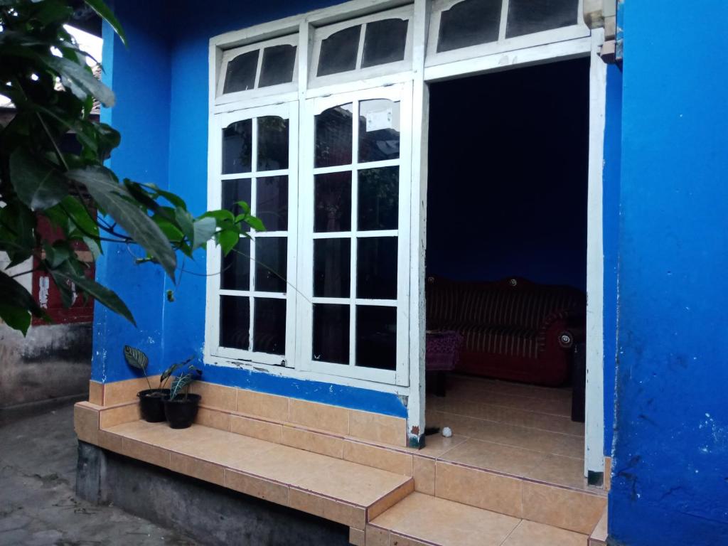 una puerta abierta a una casa azul con una pared azul en Amora Homestay, en Masbagik
