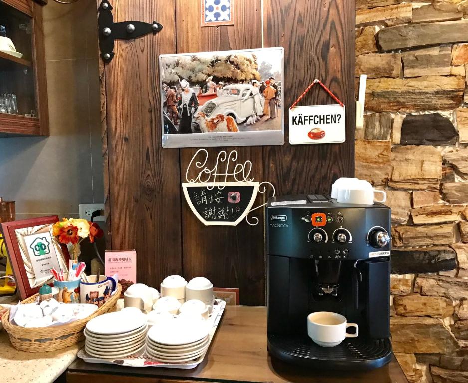 a coffee maker on a counter with cups and plates at Rothenburg Lodge in Wujie