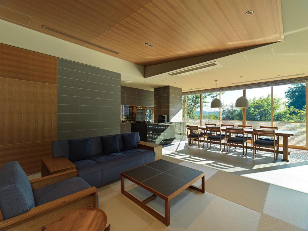 un salon avec un canapé bleu et une table dans l'établissement Lake Shikotsu Tsuruga Bessou AO no ZA, à Chitose