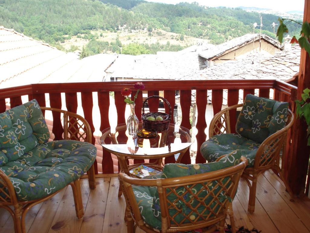 Un balcón con sillas y una mesa con vistas. en Sharkov Guest House, en Dolen