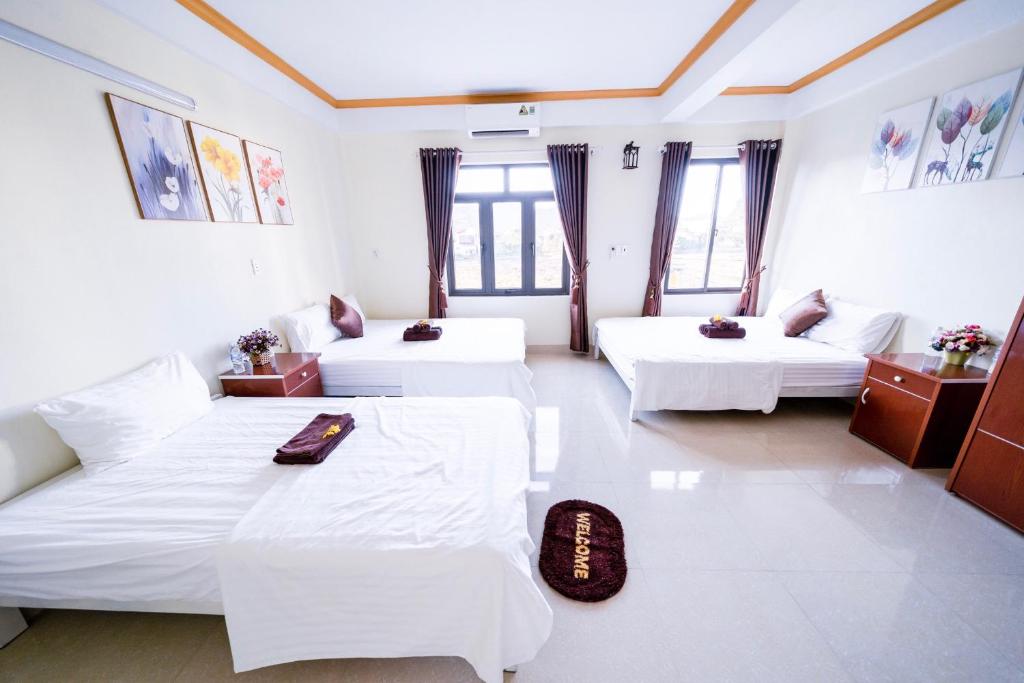 a hotel room with two beds and a couch at Golden Forest Homestay in Phong Nha