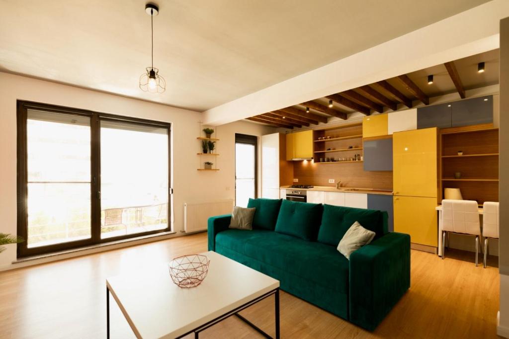 - un salon avec un canapé vert et une table dans l'établissement Apartament Aty, à Mamaia Nord – Năvodari