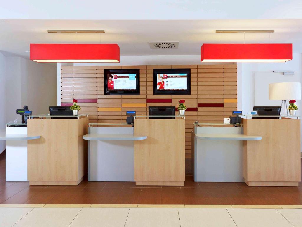 a lobby with desks and televisions in an office at Ibis Kraków Stare Miasto in Krakow