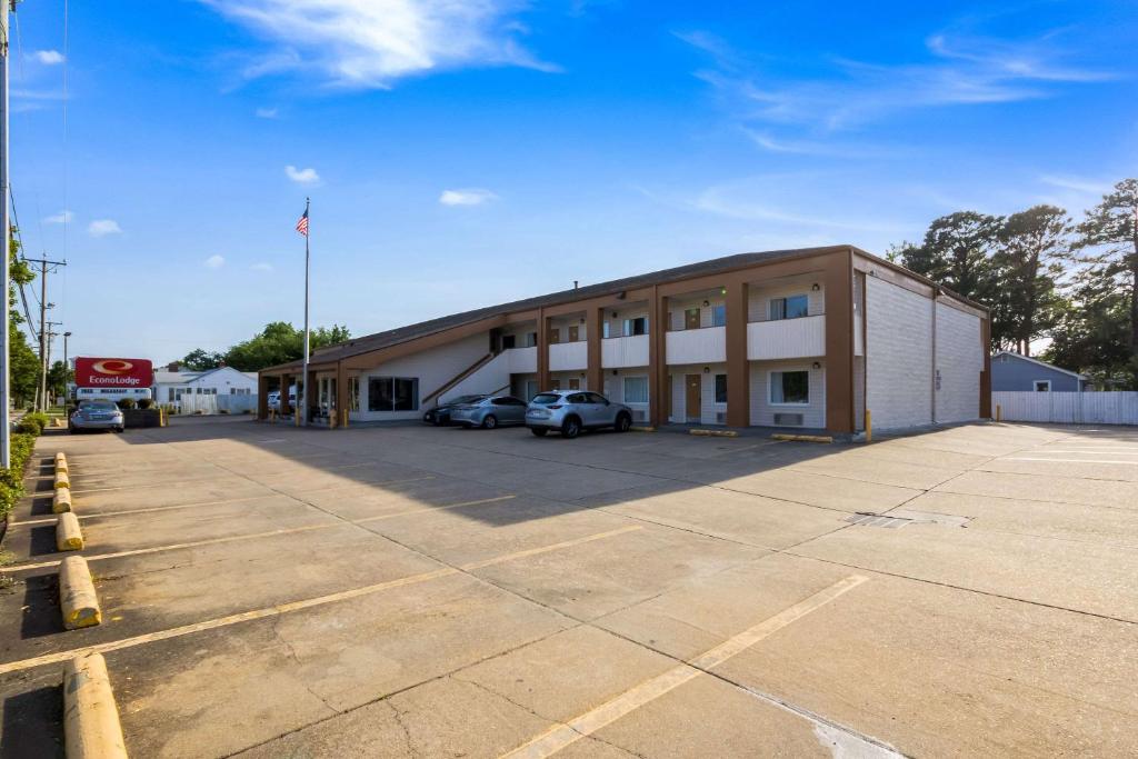 a large building with cars parked in a parking lot at Econo Lodge Little Creek in Norfolk