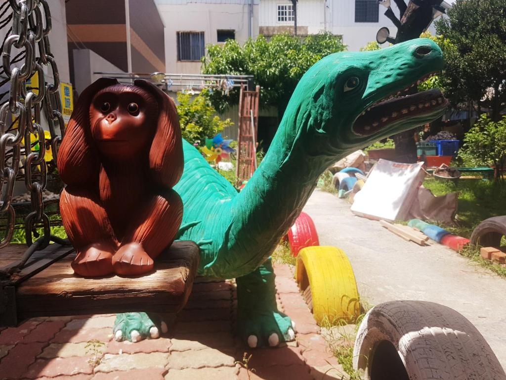 a toy dinosaur sitting on a bench at a playground at Checheng Backpackers Hostel in Checheng