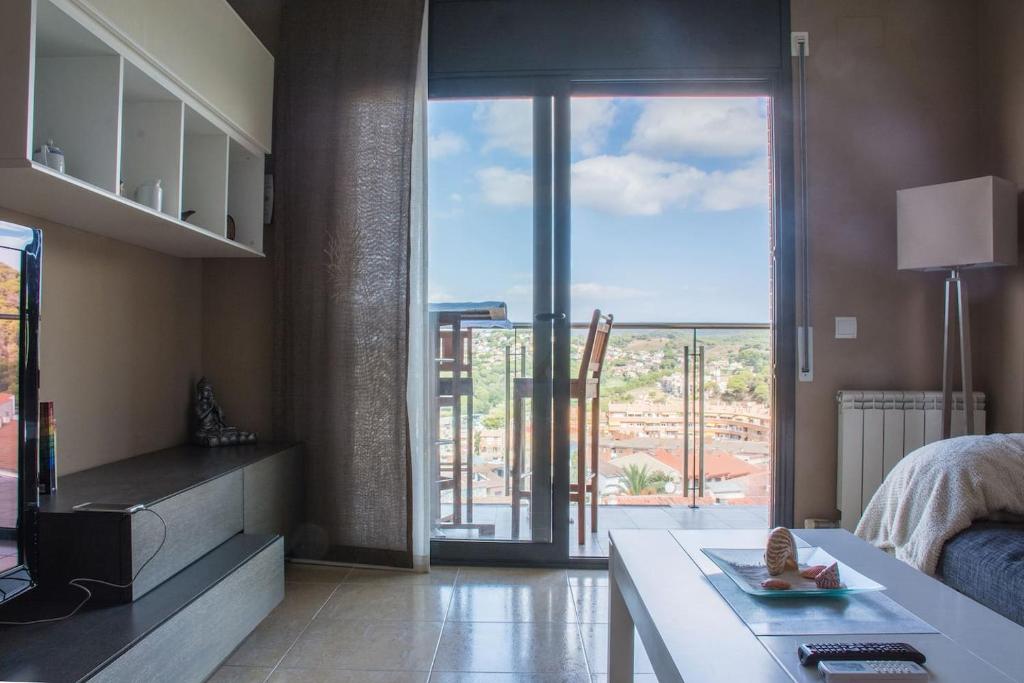 a bedroom with a large glass door to a balcony at Apartamento en Blanes con piscina y parking in Blanes