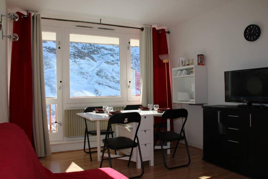 Zimmer mit einem Tisch, Stühlen und einem Fenster in der Unterkunft Studio au pied des pistes + Cellier in La Mongie