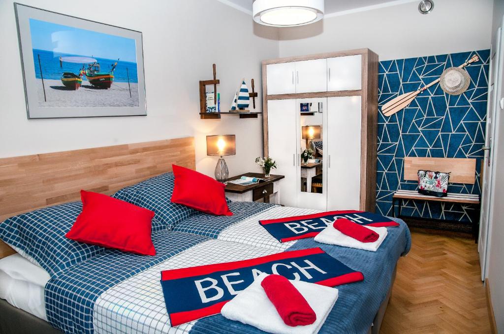 sypialnia z łóżkiem z czerwonymi poduszkami w obiekcie Blue Grey Atelier w mieście Sopot