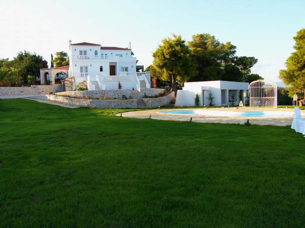 a house with a green lawn in front of a building at Ktima Nafsika - First-floor luxury apartment in majestic estate in Rozaíika