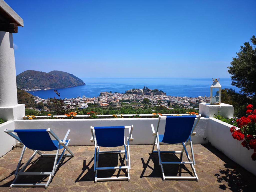 two chairs sitting on a patio with a view of the city at Villa Belvedere in Lipari