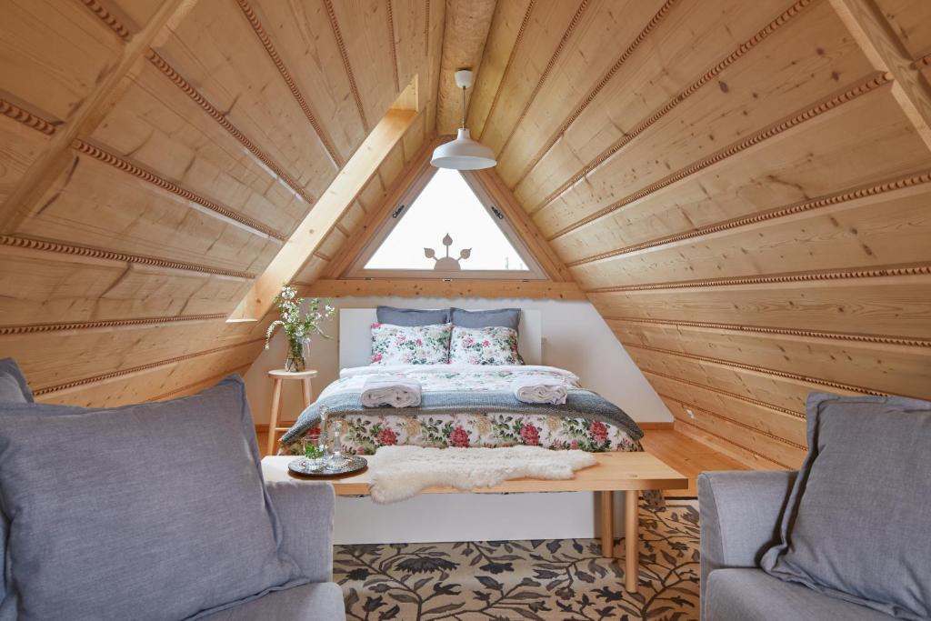 a bedroom in a tree house with a bed and two chairs at Gorce Oasis in Szlembark