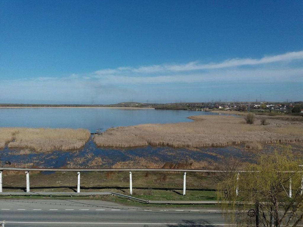 un camino junto a un cuerpo de agua con una valla en Motel Corsar, en Tulcea