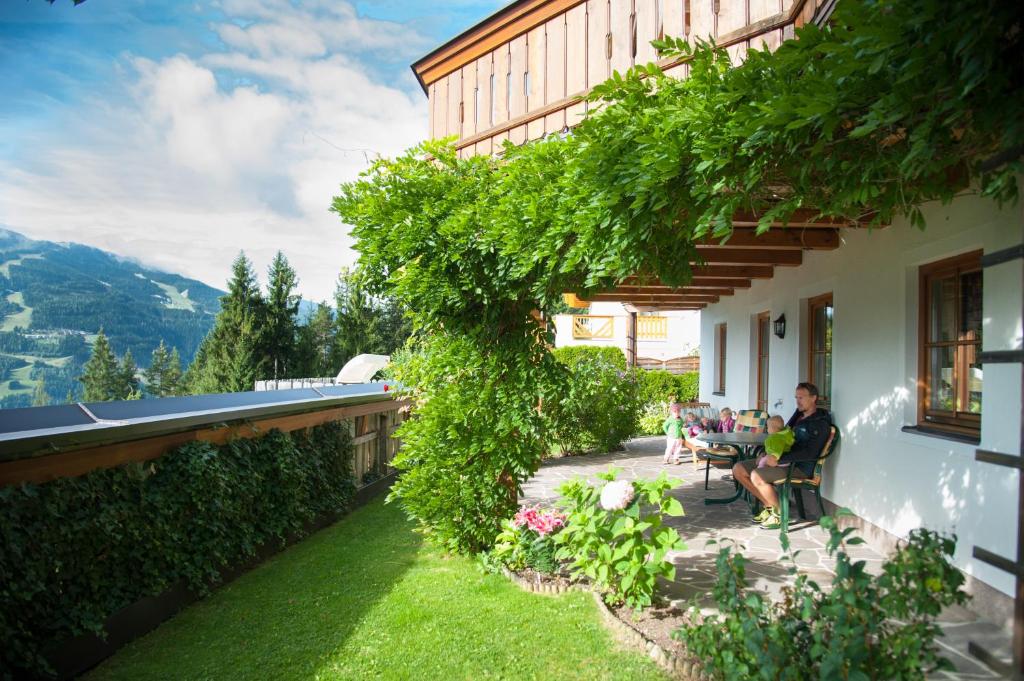 a couple sitting on a patio outside of a house at Appartements Tauernzauber in Schladming