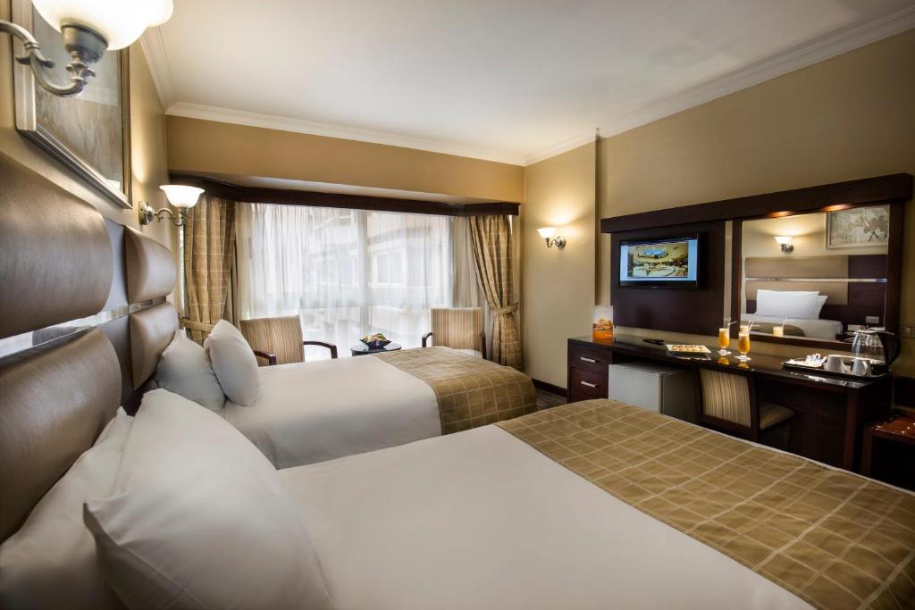 Postel nebo postele na pokoji v ubytování Pyramisa Suites Hotel Cairo