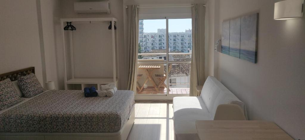 a bedroom with a bed and a view of a balcony at Sunny Suites Jupiter Apartments in Benalmádena
