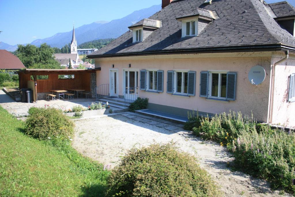 ein altes Haus mit einer Terrasse davor in der Unterkunft Pro's Villa Nassfeld-Pressegger See in Hermagor