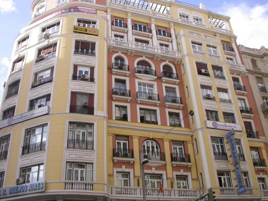 un gran edificio amarillo con muchas ventanas en Hostal Buenos Aires, en Madrid