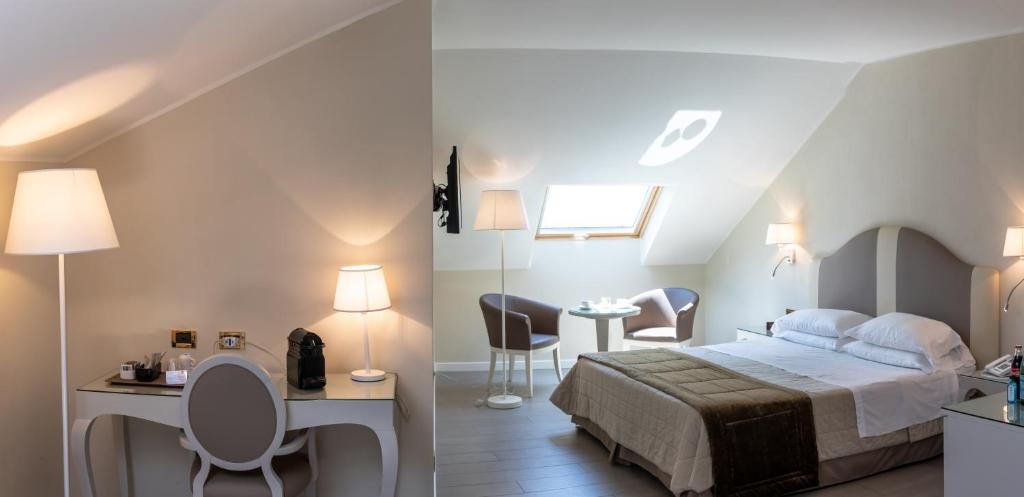 a bedroom with a bed and a desk and chairs at Hotel Miramare & Spa in Sestri Levante
