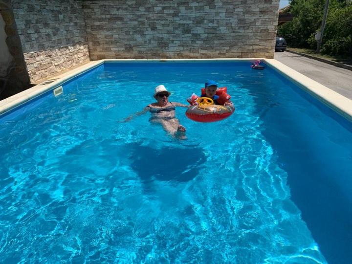 two children playing in a pool in a swimming pool at Villa Omiros in Byala