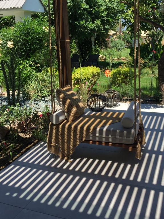 a swinging chair on a patio with a garden at Nikos Ikies in Theologos