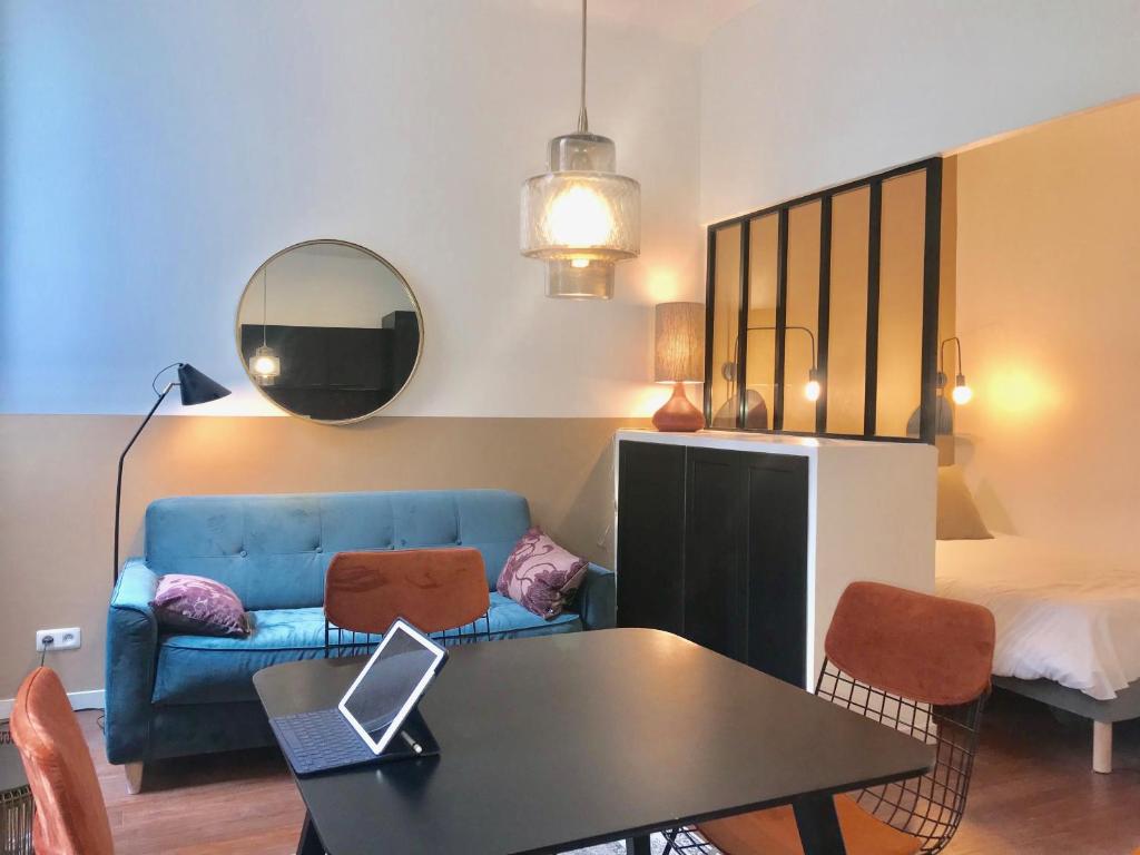 uma sala de estar com um sofá e uma mesa com um computador portátil em Marseillement votre em Marselha