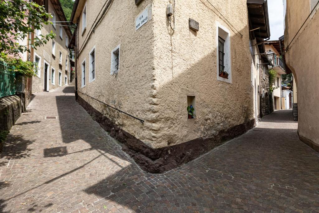 alejka z zieloną rośliną w rogu budynku w obiekcie Ostello di Germagno w mieście Omegna