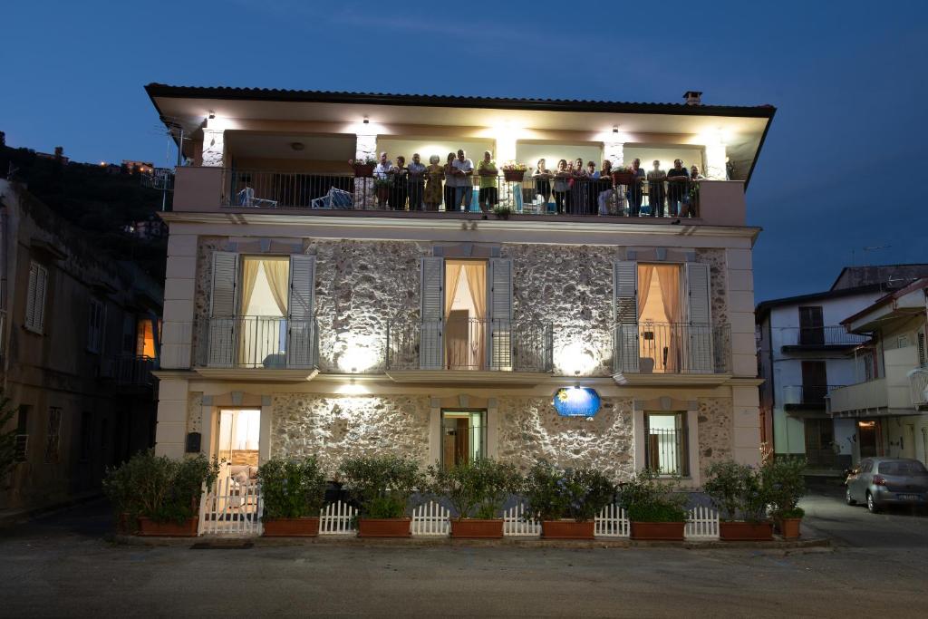 un grupo de personas de pie en el balcón de un edificio en Casa del Sole, en Nicotera Marina
