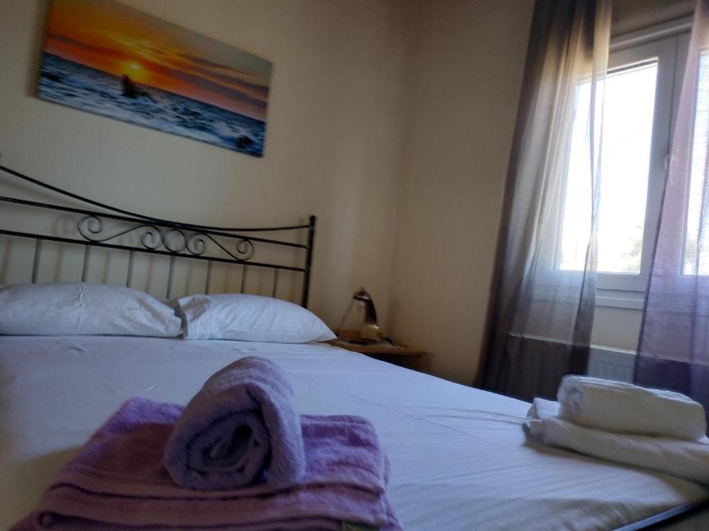 a bedroom with a bed with a towel on it at Near AirportAnd metropolitan Penelopi Cozy Home in Artemida