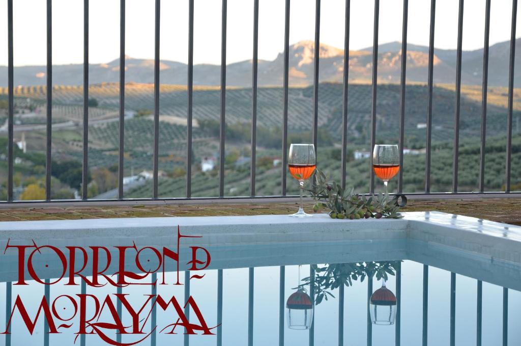 dos copas de vino sentadas en la parte superior de un balcón en Torreón de Morayma en Baena